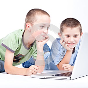 Boy using a modern laptop computer while lying on the floor
