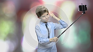 Boy using monopod on blurred background.