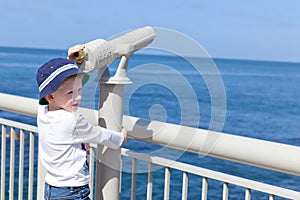 Boy using seaside binoculars