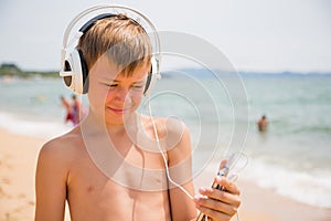 Boy using a smartphone on the beach summer day
