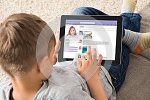 Boy Using Social Networking Site On Digital Tablet