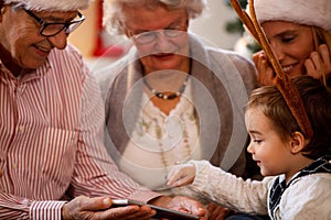 Boy using tablet, family spending Christmas time together