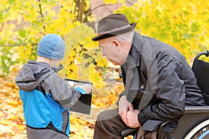 Boy using a tablet pc with grandfather watching