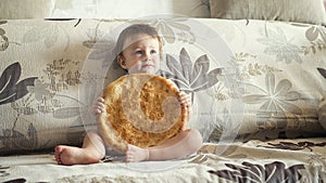 Boy with uzbek cake on the couch at home