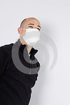 Boy with virus protection mask covid 19 with black jersey and white background with a gesture of concern
