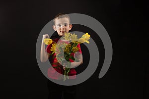 a boy with vitiligo in a red T-shirt with a bouquet of mimosa