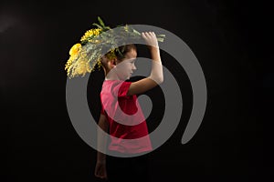 a boy with vitiligo in a red T-shirt with a bouquet of mimosa