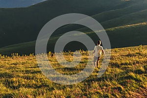 Boy with Vizsla Dog Running Downhill in Mountains