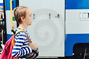 Boy waiting for express train on railway station platform. Kid with backpack on a subway