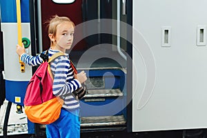 Boy waiting for express train on railway station platform. Kid with backpack on a subway