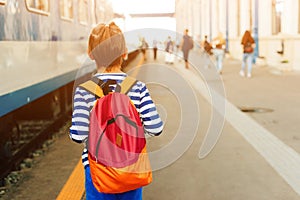 Boy waiting for express train on railway station platform. Kid with backpack on a subway