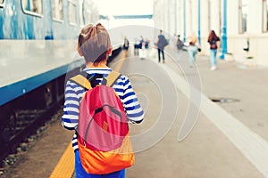 Boy waiting for express train on railway station platform. Kid with backpack on a subway