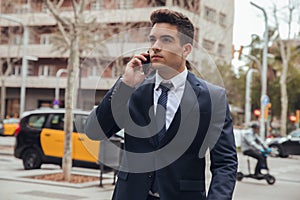 Boy walking with blue suit and calling by phone in city