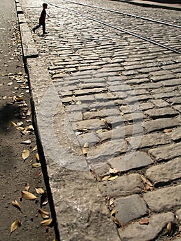 Boy walking cobblestones