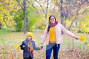 Boy walking with his mother in autumn park