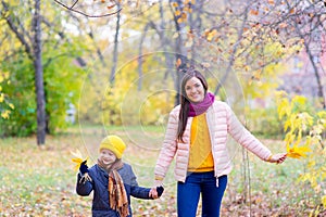 Boy walking with his mother in autumn park