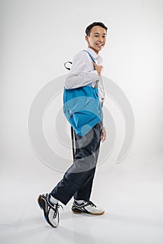 a boy walking in junior high school uniform smiling with carrying a backpack