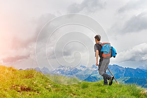 Boy walking in the mountains with his stick in the meadows