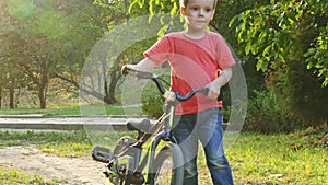 Boy walking in the park with a bicycle