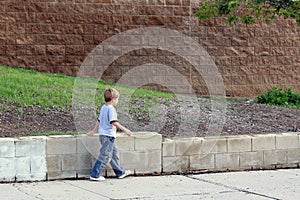 Boy walking on sidewalk