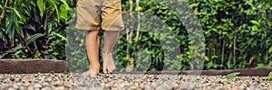 Boy Walking On A Textured Cobble Pavement, Reflexology. Pebble stones on the pavement for foot reflexology BANNER long format