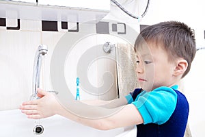 Boy washing hands, child personal health care, hygiene concept, kid washing hand in wash basin in bathroom