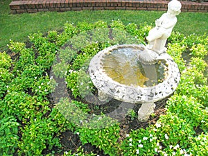 Boy water statue in the garden background