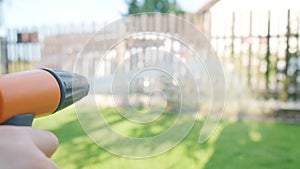 Boy watering with hose green garden