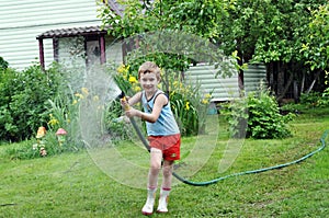 Boy watering lawn with hose