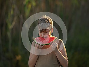 boy with a watermelon on a dark background.