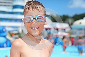 Boy in watersport goggles near pool in aquapark