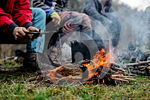 Boy waving a blow on the pan on the bonfire