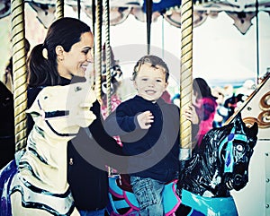 Boy Waving on a Carousel Ride with Mother - Retro