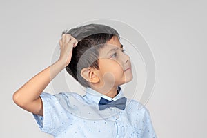 The boy wearing blue shirt with tie-bow thinking about someth