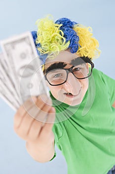 Boy wearing clown wig and fake nose holding money