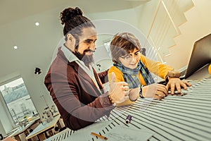 Boy wearing glasses feeling involved in working in atelier