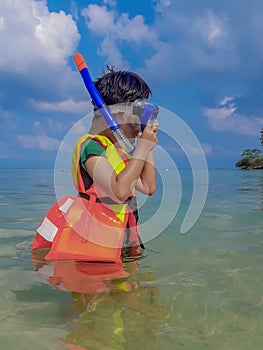 Boy wearing a life jacket, scuba diving in the sea