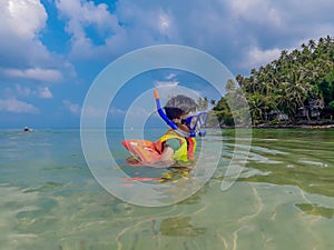 Boy wearing a life jacket, scuba diving in the sea at Haad salad Beach , koh Phangan Suratthani.