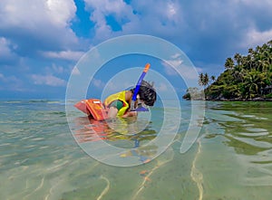 Boy wearing a life jacket, scuba diving in the sea at Haad salad Beach , koh Phangan Suratthani.