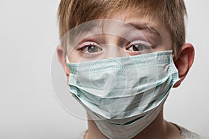 Boy wearing medical mask to protect from viruses. Portrait child close up in surgical mask