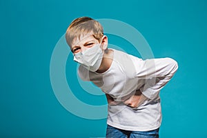 Boy wearing protection mask having stomach ache