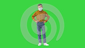 Boy wearing protective face mask looking at camera on a Green Screen, Chroma Key.