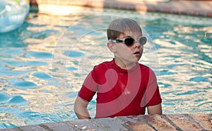 Boy wearing red shirt and goggles in pool