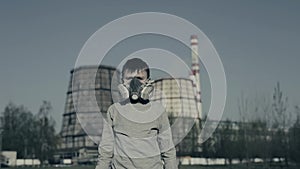 Boy wearing a respirator against factory chimneys. Air pollution concept.