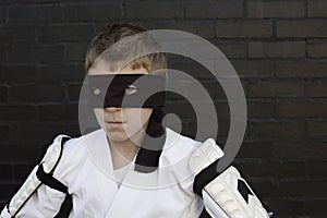 Boy wearing Zorro blindfold and fencing costume photo