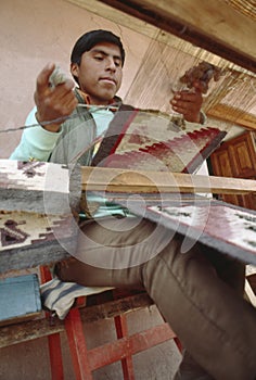Boy weaving textiles in Cusco, Peru