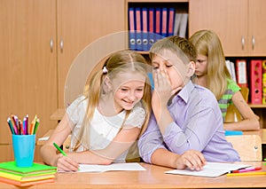 Boy whispers in the ear of the girl