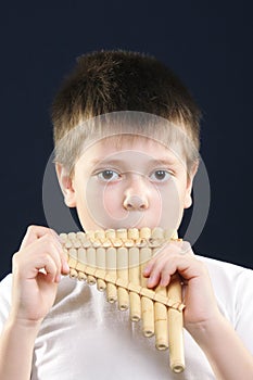 Boy in white playing panflute photo