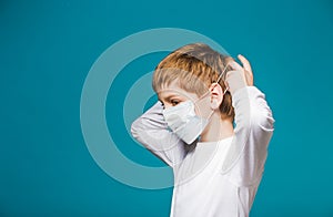 Boy in white putting on protection mask