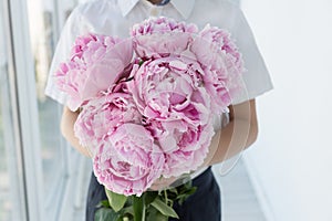 boy in white shirt hold big gentle bouquet of pink peony.